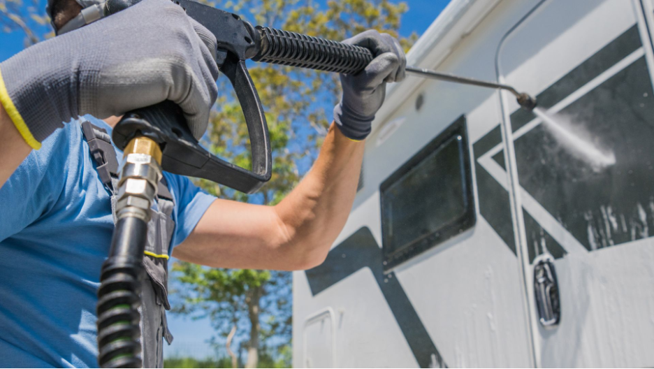 Professional commercial pressure cleaning service in action, power washing an RV with precision and care to restore its appearance.