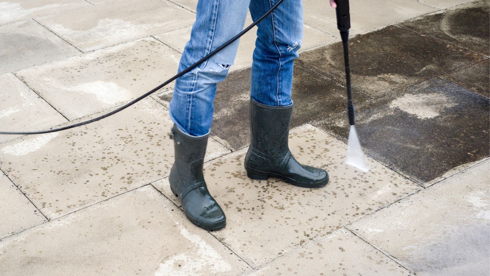 Soft washing in progress, with a clear line between the cleaned and dirty paving stones, showing the immediate results of the high-pressure cleaning.